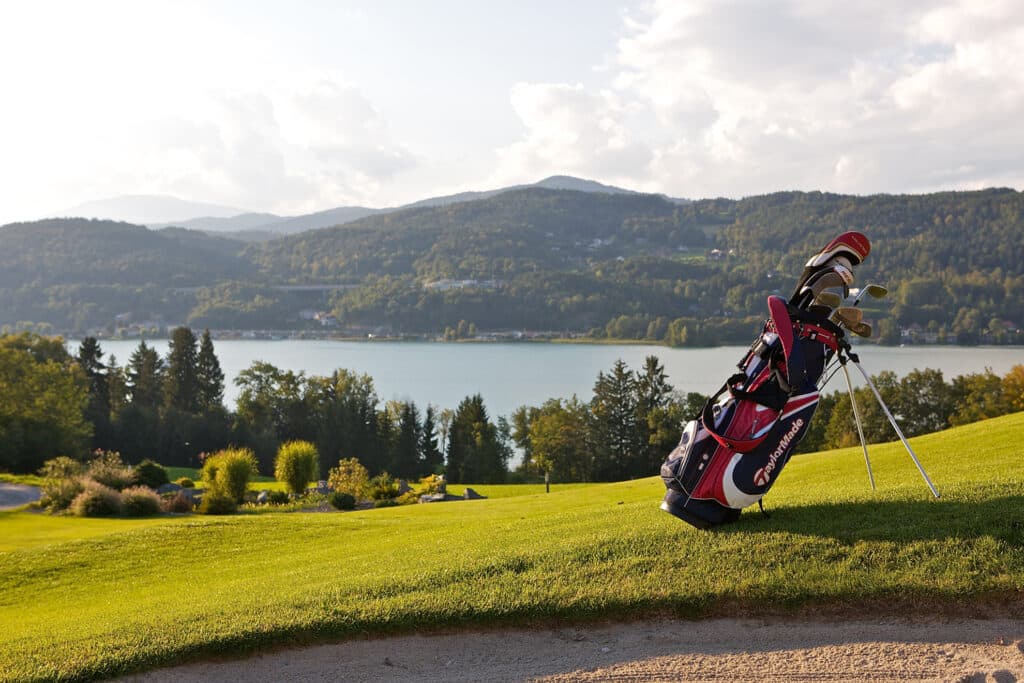 Golfer auf dem 18-Loch-Platz des Golfclubs Klopeinersee Südkärnten mit Blick auf Berge und See, ideal für Eltern im Sommerurlaub am Petschnighof.
