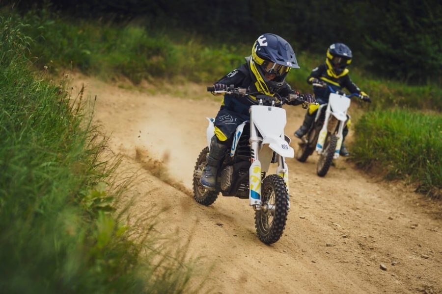 Zwei Kinder fahren mit kleinen Motocross-Bikes über eine Dirt-Strecke – actionreiches Outdoor-Erlebnis im Familienhotel Petschnighof in Kärnten für aktive Familien